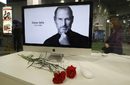 Карамфили пред компютърен екран, показващ портрет на съоснователя и бивш изпълнителен директор на Apple Стив Джобс в магазин в Санкт Петербург. На 6 октомври 2011 г. Джобс почина на 56-годишна възраст след дългогодишна борба с рака.