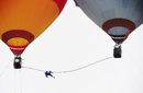 Саимаити Айшан на въже дълго 15 метра и опънато между два балона след като е изгубил баланс, опитвайки се да постави 100-метров рекорд за височина в провинция в Китай на 6 август. Той е племенник на китайския акробат Адили, известен като "Принцът на опънатото въже", и е първият опитал се да ходи по въже между два балона.