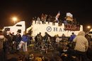 Демонстранти от "Окупирай Оукланд" седят върху камион пред пристанището по време на опитите за затваряне на западните пристанища в Оукланд, Калифорния, на 12 декември.<br /><br />Същия ден активисти на движението успяха да затворят няколко терминала. На някои места се стигна до сблъсъци с полицията. Те обаче не успяха да наложат пълна блокада на търговията, както бяха планирали.<br /><br />