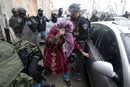 Израелски полицай под прикритие, преоблечен като палестинска жена, отваря вратата на кола, след като е задържал палестински демонстрант по време на сблъсъци в бежанския лагер Шуафат на Западния бряг на 15 май.