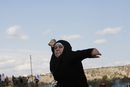 Палестинка хвърля камък по израелски войници по време на протест срещу поставената от Израел бариера, разделяща село Билин близо до Рамала на 7 януари.