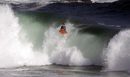 Бугибордър се носи по вълната на плажа Нюпорт в Калифорния