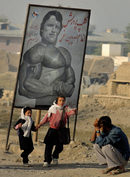 Деца преминават покрай плакат с лика на Шварценегер, който рекламира нов клуб за бодибилдинг в афганистанският град Кабул.
