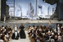 Бледата красота на разпадащ се театър, чийто завеси се отварят, за да разкрият ултрамодерна гледка от град на бъдещето, бе фон на ревюто с висша мода на Карл Лагерфелд за Chanel, сезон есен-зима 2013-2014 г.