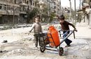 Деца бутат количка с контейнери за вода по улица в старта част на Алепо, Сирия.