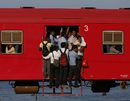 Хора висят от претъпкан местен пътнически влак на път за Коломбо, Шри Ланка.