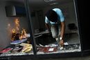 Антиправителствен демонстрант скача през прозореца, след като е подпалил офис, по време на сблъсъци в Каракас, Венецуела.