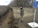 Украински офицер стои до канавка на украинско-руската граница близо до граничния пункт на Новоазовск.