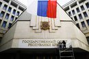 Работници поставят нови знаци на сградата на местния парламент в Симферопол, Крим.