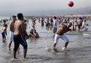 Момчета ритат топка на плажа в Лима, Перу.