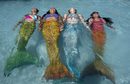 Инструкторка във Филипинската плувна академия за русалки учи момичетата да се задържат над вода.