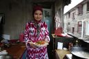 Патема Юсуф, 22, държи чиния с нудли, характерни за кухнята на Сиднзян, Китай, в дома си в Шанхай, Китай