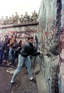 Германец разрушава Берлинската стена под погледа на източногерманските граничари на 11 ноември 1989 г.