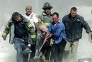 Спасители евакуират тежко ранения свещеник на нюйоркската противопожарна служба Майкъл Джъдж от една от двете кули-близнаци в града на 11 септември 2001 г.
