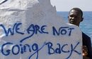 Мигрант държи плакат с надпис "Няма да се върнем"  на граничния пункт Сент Людовик на брега на Средиземно море между Вентимиля, Италия и Ментон, Франция. В събота около 200 мигранти, главно от Еритрея и Судан са се опитали да преминат границата от Италия и бяха блокирани от италианската полиция и френските жандармеристи.