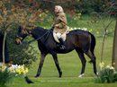 На този кадър от 2 април 2002 г. Елизабет язди кон в градините на Уиндзор.