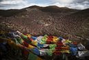Тибетски молитвени знамена се виждат над долината Ларунг и будисткият институт, който се намира на близо до 4000 метра надморска височина, в отдалечения окръг Сертар, провинция Съчуан, Китай.