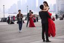 Двойки се подготвят за снимки, на крайбрежната зона Бунд в Шанхай, Китай