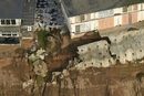 Жилищни комплекси на ръба на скалите, а дворовете им се изсипват в океана – това е гледка, която се вижда от въздушни кадри от репортаж на местна телевизия. 
