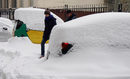 Хора минават покрай заснежени автомобили, след обилен снеговалеж в Алмати, Казахстан.