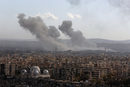 Дим се издига след въздушни удари по Алепо, Сирия.