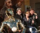 Роботът C-3PO, Чубака, Джордж Лукас, Кари Фишър, R2D2 и Марк Хамил през 1997.