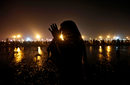 Хиндуистки поклонници се потопиха в реката Ганг в навечерието на еднодневния фестивал Makar Sankranti, южно от Калкута, Индия.