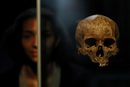 Служителка в Музея на Лондон позира за снимка до човешки череп, който е част от експозицията Tunnel: The Archaeology of Crossrail.