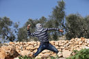 Палестинско момче хвърля камък срещу израелски полицаи по време на протест близо до еврейското селище Куадомем на Западния бряг.