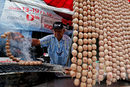 Продавач на печена наденица в град Након Саван,Тайланд. Наскоро властите в Банкок взеха решение да ограничат уличната храна в столицата, в провинцията обаче бизнесът процъфтява.