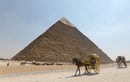 Туристи обикалят с файтони района на пирамидите в Гиза, Египет.