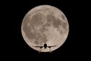Пътнически самолет е видян на фона на пълната луна по пътя към летище Хийтроу в Лондон, Великобритания<br /><br />