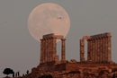 Луната се издига над Храма на Посейдон, древният гръцки бог на моретата, на изток от Атина, Гърция.
