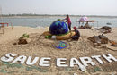 Студенти правят пясъчна скулптура за Деня на земята на брега на река Ямуна в Алахабад, Индия.