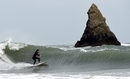 Сърфист се опитва да хване голяма вълна край Пемброкшир, Уелс, Великобритания.