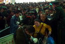 Полицай се опитва да въведе ред при влизането в гарата на град Фужоу.