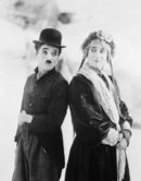 През 1912 г. Чаплин е забелязан от американския продуцент Мак Сенет, който го кани да се присъедини към Нюйоркската филмова компания. Първият му договор е за 150 долара на седмица и след като 2 години наблюдава процесите на филмопроизводството, през 1914 г. излиза дебютният му филм "Да заработваш прехраната си".<br /><br />На снимката: Чарли Чаплин с доведения си брат Сидни Чаплин