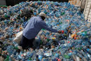 Служител сортира пластмасови бутилки във фабриката за рециклиране на пластмаса близо до Найроби, Кения.