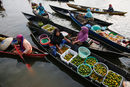 Жени продават плодове и местни продукти в лодки в река Мартапура до село Лок Байтан, Индонезия.