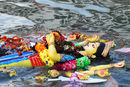 Статуя на индуистката богиня Дурга плава по водата след потапяне в река Буриганга в последния ден от фестивала "Дурга Пуджа" в Дака, Бангладеш.