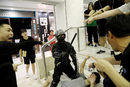 Полицай от службата за борба с безредиците задържа протестиращ в търговски център в Тай По в Хонконг, Китай.
