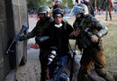 Полицаи отвеждат фотографът Жеремиас Гонзалез по време на протест срещу правителството в Чили.
