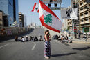 Жена държи знамето на Ливан по време на антиправителствен протест в Бейрут, Ливан.