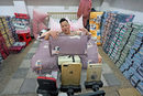 Лайфстриймър промотира легло по време на ежегодния ден на необвързаните в китайски град.