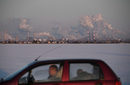 Мъж в автомобил минава покрай нефтената рафинерия на "Газпром" в Омск, Русия.