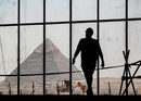 Работник на фона на пирамидите в Гиза, Кайро, Египет.