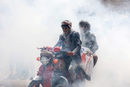 Хора карат мотор на фона на дим от дезинфекция в покрайнините на Сана, Йемен.