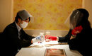 Клиентите, носещи защитни маски и ръкавици, вдигат тост в тематичния ресторант "Cheers One" в Токио, Япония.