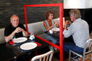 Мениджъри тестват социалните прегради от плексиглас, инсталирани между масите в ресторант в Брюксел, Белгия.