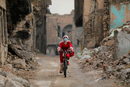 В навечерието на Коледа 23-годишната Шайма ал Абаси раздава подаръци на децата в Мосул, за да подобри настроението по време на празничния сезон.<br /><br />Сред разрушените сгради Ал Абаси, облечена в червено-бяла дреха, обикаля стария град, пеейки, докато кара колелото си.<br /><br />"Децата много се нуждаят от подаръците заради това, което ДАЕШ ("Ислямска държава") направи по време на войната, кризата и натиска, от които страдаха децата", казва Шайма.